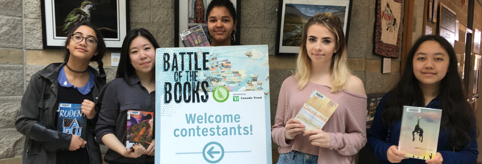 Five female students holding Battle of the Books sign and their books