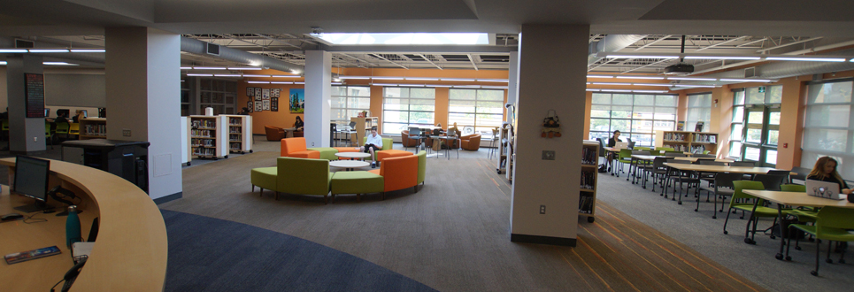 Tables, chairs, books in the Learning Commons area